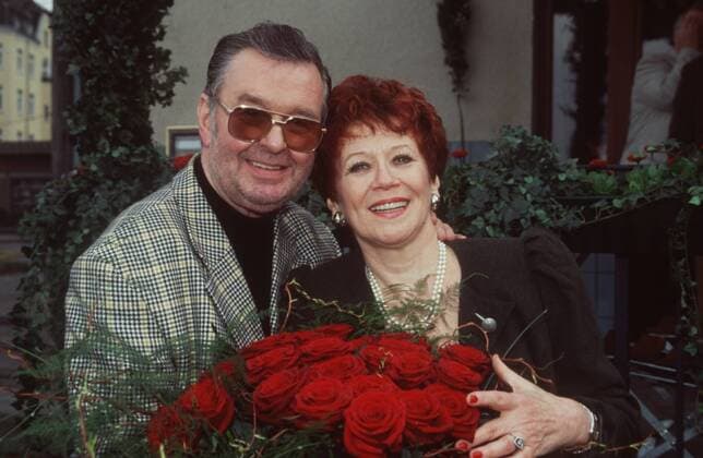 Ernst H. Hilbich mit Lebensgefährtin Lotti Krekel 03 01 pp Mann Schauspieler Schauspiel Theater TV Fernsehen Komiker Komik dunkelhaarig kurzhaarig leger festlich stehend draussen halb quer lächelnd angelehnt umarmend Blumen Blumenstrauss rote Rosen rot Fototermin 70. Geburtstag Ernst Hilbich am 16.03.2001 siebzigster siebzig 70