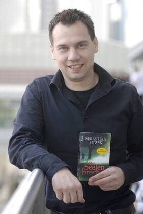 Sebastian Fitzek (Autor) 10 08 thg Sebastian Fitzek am 17. Oktober 2008 auf der Buchmesse in Frankfurt Main Deutschland deutsch Deutscher Mann Schriftsteller Schriftstellerei Literatur Journalist Journalismus german author writer journalism leger Jeans Hemd hoch halb stehend angelehnt anlehnend lächelnd Buch Buchtitel Buchcover Cover Titel Der Seelenbrecher haltend Frankfurter Messe exklusiv draußen