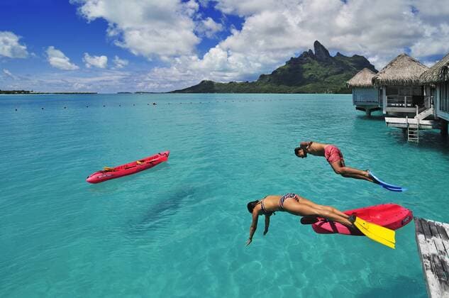  Urlauber springen ins Wasser, Saint Regis Bora Bora Resort, Bora Bora, Inseln unter dem Wind, Gesellschaftsinseln, Französisch-Polynesien, Pazifischer Ozean iblnex02197964