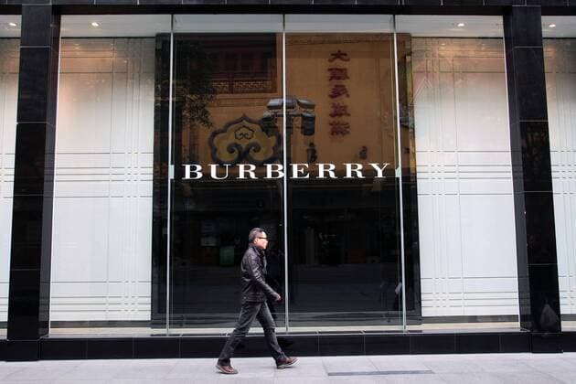 --File--A pedestrian walks past a Burberry boutique in Shanghai, China, 6 April 2012. Burberry has been awarded ¡ê63 million ($100 million) in damages after taking a network of Chinese counterfeiters to court. WWD report that the defendants, who ran websites such as yesburberryvision.com and buyburberry.com, were known to have sold at least 22 different product types all bearing imitations of the British heritage brands various trademarks, such as its iconic plaid check and equestrian knight logo. The resolution of the case, which was originally filed in January at Manhattan Federal Court, comes after months of waiting for the defendants to reply to the accusations and appear in court - neither of which was ever done. The domain names for all the infringing sites will now be transferred to Burberry, allowing the brand to cut off any associated internet providers, web designers, sponso  20120406_27124