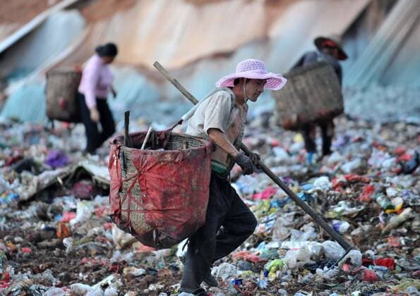 (120715) -- NANNING, July 15, 2012 (Xinhua) -- Scavengers look for recyclable things at a trash dump in Nanning, capital of south China s Guangxi Zhuang Autonomous Region, July 14, 2012. A group of scavengers makes their living from the trash dump in the south of Nanning. Everyday before processed, 2000 tonnes of trash were transported and piled up at the dump. The scavengers select recyclable things and sell the for money. (Xinhua Zhou Hua) (zhs) CHINA-NANNING-SCAVENGERS (CN) 