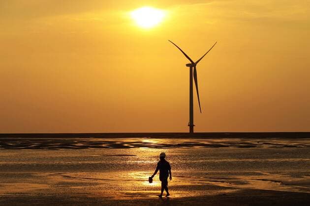 (120901) -- NANTONG, Sep. 01, 2012 (Xinhua) -- A worker walks past a wind turbine at an offshore construction site of Longyuan Rudong 150MW Intertidal Trial Wind Farm in Rudong county of Nantong City, east China s Jiangsu Province, Aug. 17, 2012. The pile sinking operation, part of the wind turbine installation, conducted by Jiangsu Longyuan Zhenhua Marine Engineering Co., LTD was completed on Aug. 31, setting a world record with the verticality of 0.012 percent deviation. (Xinhua Xu Congjun) (lx) CHINA-JIANGSU-NANTONG-INTERTIDAL WIND FARM (CN) 