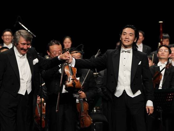 PARIS, Oct. 1, 2012 -- The first conductor of China s National Symphony Orchestra Michel Plasson (front L) from France and Chinese pianist Wu Muye (front R) greet the audience during a symphonic concert held by China s National Symphony Orchestra in Paris, capital of France, on Oct. 1, 2012. (Xinhua Gao Jing) (syq) FRANCE-PARIS-CHINA-SYMPHONY ORCHESTRA-CONCERT 