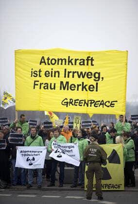 Mahnwache Atomkraft abschalten DEU, Deutschland, Germany, Berlin, 15.03.2011 Demonstranten mit Plakat Atomkraft ist ein Irrweg Frau Merkel von Greenpeace bei der Kundgebung und Mahnwache fuer den Atomausstieg unter dem Motto Atomkraft abschalten, Atomausstieg jetzt vor dem Bundeskanzleramt in Berlin. Die Kundgebung organisiert von Campact und anderen Antiatominitiativen fordert die Abschaltung aller Atomkraftwerke und erinnert an die Auswirkungen der Naturkatastrophe in Japan und das Desaster der japanischen Atomkraftwerke. Kundgebung gegen die Atompolitik der schwarz-gelben Koalition und der Bundesregierung. Atomkraft Nein Danke, Atomkraftgegner, Antiatombewegung, Anti-Atom-Demo, Antiatom, Anti-Atomkraft, Atomkraft, Atomkraftwerke, Anti-Atom, Anti-Atom-Bewegung, Atomenergie, Atompolitik, Anti, Atomenergie, Demonstration, demonstrieren, Demonstrant, Demonstranten, Atomkraftgegener, Kern
