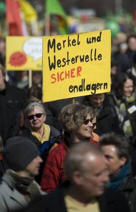Demonstration fuer den Atomausstieg DEU, Deutschland, Germany, Berlin, 26.03.2011 Demonstrant mit Plakat Merkel und Westerwelle sicher endlagern bei der Demonstration mit ca 90.000 Menschen fuer den Atomausstieg unter dem Motto Fukushima mahnt alle AKWS Abschalten fuer einen sofortigen Ausstieg aus der Atomenergie in Berlin. Die bundesweiten Demonstrationen thematisieren die Auswirkungen der Naturkatastrophe in Japan und das Desaster der japanischen Atomkraftwerke. Kundgebung gegen die Atompolitik der schwarz-gelben Koalition und der Bundesregierung. Atomkraft Nein Danke, Atomkraftgegner, Antiatombewegung, Anti-Atom-Demo, Antiatom, Anti-Atomkraft, Atomkraft, Atomkraftwerke, Anti-Atom, Anti-Atom-Bewegung, Atomenergie, Atompolitik, Anti, Atomenergie, Demonstration, demonstrieren, Demonstrant, Demonstranten, Atomkraftgegener, Kernkraft, Kernkraftwerk, Kernkraftwerke, Kernenergie, Atomlobby,