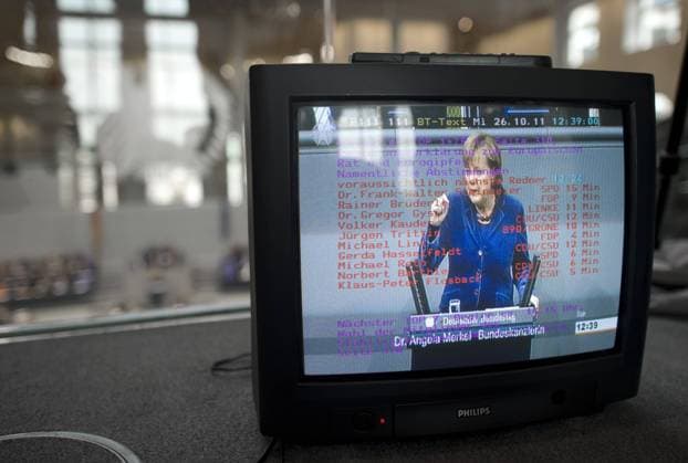 Angela Merkel, Bundestag, Debatte Euro-Rettungsschirm DEU, Deutschland, Germany, Berlin, 26.10.2011 Rede von Bundeskanzlerin Angela Merkel CDU, gesehen durch einen Fernseher im Plenarsaal Deutscher Bundestag anlaesslich der Debatte zum Euro-Rettungsfond EFSF und dem Bruesseler Spargipfel. Der Bundestag stimmt ueber die Erweiterung des Rettungsscgirms ab, der mittels eines Hebels das europaeische Waehrungssystem stabilisieren soll. Plenarsaal Deutscher Bundestag, Deutschen Bundestag, Plenum, Deutscher Bundestag, Parlament, Bundestagsdebatte, Plenardebatte, Deutsche Politik, Bundespolitik, QF Querormat, 2011, Symbol Symbolfoto, Symbolbild, Symbolisch, Haushalt, Bundeshaushalt, Sparhaushalt, Finanzen, Finanzwirtschaft, Wirtschaft, Schulden, Sparen, Einsparen, EU Waehrung, Euro, europaeische, Europa, Feature, Fiskus, Finanzamt, Fiskus, Geld, Oeffentlicher, Haushaltspolitik, Kasse, Kassen, St