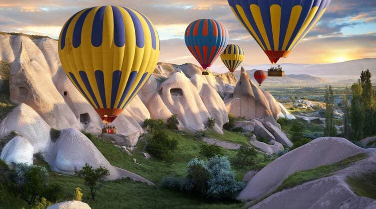 Heißluftballons über den vulkanischen Tuff-Felsformationen von Göreme in der Morgendämmerung, Kappadokien, Türkei iblpwp02411454