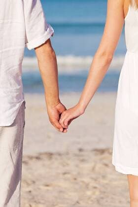 junges verliebtes paar im sommer am strand hand in hand