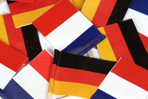 Flaggen der Republik Frankreich und Bundesrepublik Deutschland liegen auf einem Stapel