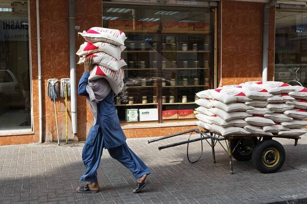 IMAGO Nature: Unsere Erde, Klimawandel, Ernährung, Pflanzen der Zukunft, Linse Arbeiter trägt Säcke mit Linsen auf der Schulter, Deira Old Souk, Dubai, Vereinigte Arabische Emirate, Naher Osten iblkas02418114.jpg