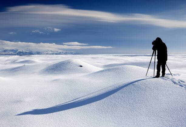 Naturfotograf fotografiert eine Winterlandschaft, Island nature photographer taking photos in snowy landscape, Iceland BLWS332020