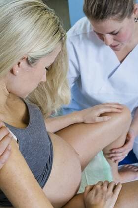  Mann und Frau im Kreißsaal während der Entbindung, die Frau sitzt während der Wehen auf dem Geburtshocker und wird von ihrer Hebamme betreut ibljmt03031794.jpg