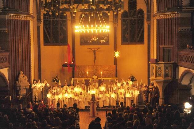 Gemeinsames Luciafest der schwedischen Gemeinde und schwedischen Schule in der Auenkirche in Berlin-Wilmersdorf. Das Luciafest ist ein vorweihnachtlicher Brauch, der vor allem in Schweden verbreitet ist. Das Fest fällt immer auf den 13. Dezember, der in den christlichen Kirchen der Gedenktag der Heiligen Lucia ist und vor der Gregorianischen Kalenderreform der kürzeste Tag des Jahres war. Obwohl das Luciafest dem Namen nach ein Heiligengedenktag ist, ist es heute wenig kirchlich geprägt. Die wichtigsten Elemente sind das Tragen von weißen Gewändern und Kerzen, der Verzehr von traditionellem Safrangebäck (lussekatter), das Singen von Lucialiedern, und die Wahl einer örtlichen Lucia. Die Feierlichkeiten beginnen meist am Morgen in der Familie und setzen sich in Kindergärten, Schulen und am Arbeitsplatz fort. Ein Mädchen, in der Familie traditionell die älteste Tochter, spielt die Lucia. In 377768 EDITORIAL USE ONLY