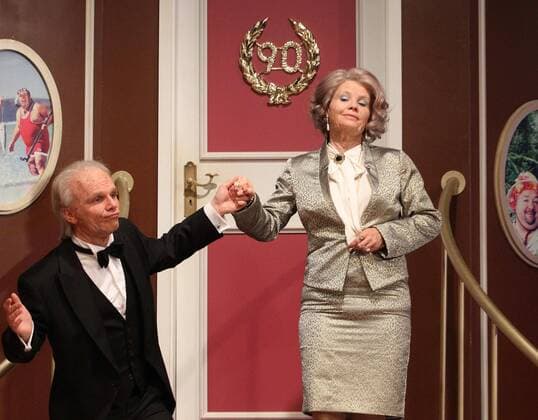 Ralf SCHMITZ (Butler James - Schauspieler Comedian) fuehrt bringt begleitet Annette FRIER (Miss Sophie - Schauspielerin Comedian) zum Essenstisch am Set Dreh von Dinner for one op Koelsch quer querformat landscape close