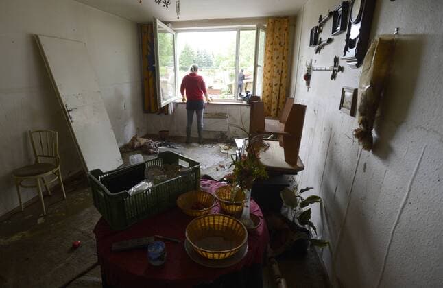 A woman looks out of a window in her flat hit by the swollen river Vltava in Vrane nad Vltavou, 22 kilometres (14 miles) South of Prague, on Thursday, June 6, 2013. Heavy rainfalls caused flooding in parts of Germany, Austria and Czech Republic. (CTKxPhoto MichalxKrumphanzl) CTKPhotoP201306060512201  kru 6