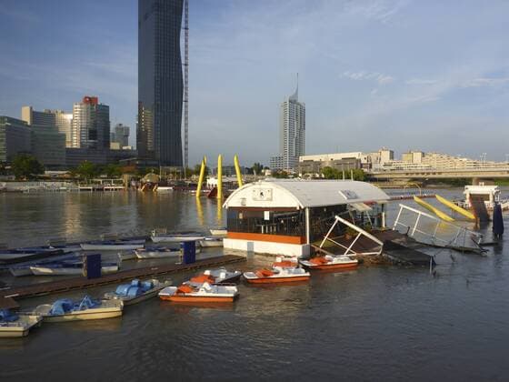 Hochwasser der Neuen Donau in Wien mit überschwemmten Lokalen der Ausgehmeile Sunken City , im Hintergrund die Donaucity