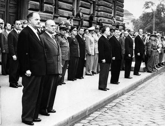 The leaders of the Austrian Republic and the ambassadors of the Big Four stand to attention in Vienna as the flags of the occupying nations are lowered in Austria s first moments of post - war freedom . ( Left to right ) Julius Raab , Chancellor of Austria ; Adolf Schaerf , Vice - Chancellor ; Francois Seydoux , French Ambassador ; I . I . Ilyichev , Soviet Ambassador ; James K . Penfield , United States Ambassador ; and Sir Geoffrey Wallinger , British Ambassador . 27 July 1955, Österreich, Vereinte Nationen, UN UnitedArchives00145716 