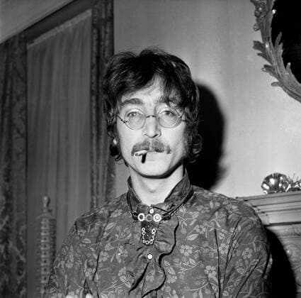 With drooping moustache , thin - rimmed specs , floral shirt and leather choker styled tie , there is no mistaking John Lennon of The Beatles , seen here at the home of the group s manager , Brian Epstein when the release of their newest LP , Sergeant Pepper s Lonely Hearts Club Band , was announced for next month . 22nd May , 1967 UnitedArchives00419771 