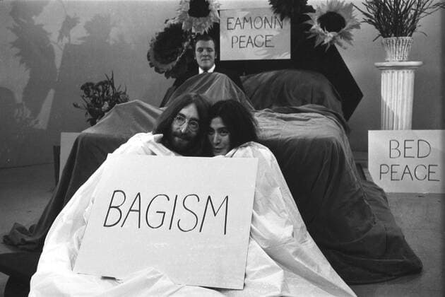 The television compete Eamonn Andrews sits in a bed during Thames Television prgramme Today . John Lennon and his wife Yoko One cuddle up together in a bag . The couple wer interviewing Eamonn on the programme . John and Yoko returned to London from Amsterdam , where they have been in bed for a week at the Hilton Hotel , as a protest against world violence . Today , they announced they were sending the world s leaders an acorn each to plant for peace 1st April 1969, Fernsehen, Fernsehshow, Fernsehstar, Fernseher UnitedArchives00703244 
