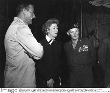 Field Marshal the Viscount Montgomeryn toured Warner Bros. Studios as the guest of Jack L. Warner. The British War Leader visited John Wayne on the set of The Sea Chase , June Allyson on The McConnell Story set and Greer Garson on the stage where she is currently starring in Strange Lady in Town . Recalling past pictures he had seen them in, Field Marshal Montgomery is pictured here with, (left to right) John Wayne, Greer Garson. Local Caption General Montgomery UnitedArchives00829033 