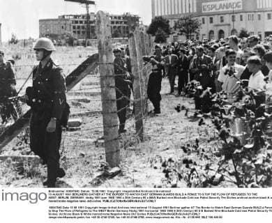 13 AUGUST 1961 BERLINERS GATHER AT THE BORDER TO WATCH EAST GERMAN GUARDS BUILD A FENCE TO STOP THE FLOW OF REFUGEES TO THE WEST, BERLIN, GERMANY. UnitedArchives00866733 