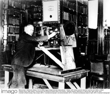 Edison with motion picture machine (not his own make) in West Orange Library 1897 Edison, Thomas Alva (the Wizard of Menlo Park) US inventor; opened research laboratory in Menlo Park, New Jersey 1876 (moved to West Orange, New Jersey 1887); invented phonograph (1st demonstrated 1877); invented incandescent electric light 1879; invented kinetograph camera and kinetoscope motion-picture viewer (patented 1891) _1847-1931 UnitedArchives00891476 