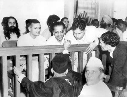 IMAGO ICONS: Mahatma Gandhi Some of the accused (Mahatma Gandhi assassination) talking to the defence counsels just before the preliminary began, at the hearing of N. V Godse. Left to right : Nathuram Vinayak Godse; Narayan Dattatraya Apto, Vishnu Ramakrishan Karkare. 31st May 1948 UnitedArchives00903269 