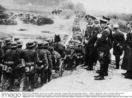WW2: Hitler and other high German officers watch the long lines of Nazi soldiers marching through the mud of Poland after Germany attacked Poland in the morning hours of 1st September 1939. Two days later England and France, to fulfill their pledge of assistance to Poland, declared war against the Nazi state and the European conflict was under way. UnitedArchives00921751 