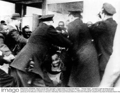 IMAGO History, U.S. Bürgerrechtsbewegung: 1954-1968 Thomas Hagan , grimaces in pain as Police struggle to free him from men who attacked him moments after the fatal shooting of Malcolm X . Hagan was later charged with his death , as he addressed a gathering of his followers in Harlem 21 February 1965 UnitedArchives00937035 