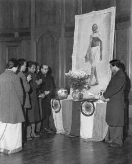 IMAGO ICONS: Mahatma Gandhi Indians pray before the portrait of their assassinated father , Gandhi, at India House in the Stran, London January 30th, 1948.  UnitedArchives00938690