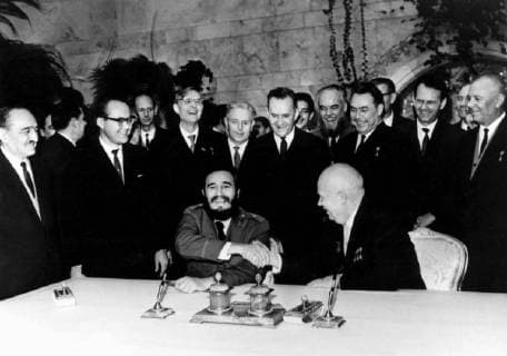 Cuban Premier Fidel Castro (seated left) shakes hands with Soviet Premier Nikita Khruschev after they had penned their signatures to an £ 890,000,000 sugar deal in the Kremlin here, 21st January 1964. On the extreme left is Soviet First Deputy Premier Anastas Mikoyan. Castro flew home on 23rd January after a ten day visit.  UnitedArchives01004409