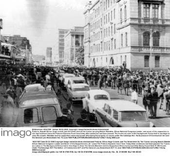 IMAGO History, Ende der Apartheid in Südafrika: 1990-1994 Pretoria, Soputh Africa: Huge crowds jam the street here as the trucks carrying Nelson Mandela. Afican National Congress Leader, and seven of his supporters to life imprisonment leave the Pretoria Supreme Court here today after sentences had been passed. The trucks are seen in the background. Police had to use dogs to clear the streets. Mandela and his supporters were imprisoned after being found guilty on counts under the Sabotage Act, the Supression Of Communism Act and the General Law Amendment Act. 12 June 1964  UnitedArchives01019918