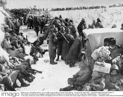Korea-Krieg 1950-1953 - Aufnahmedaten geschätzt Halted in their tracks by a Red China roadblock, these American troops try to rest along the icy trail in sub-zero temperatures....2 GI s sprawl out in the road, using it as a bed. Others rest against the hilly terrain or inside and around jeaps hoping to find an escape... December 1950  UnitedArchives01022711