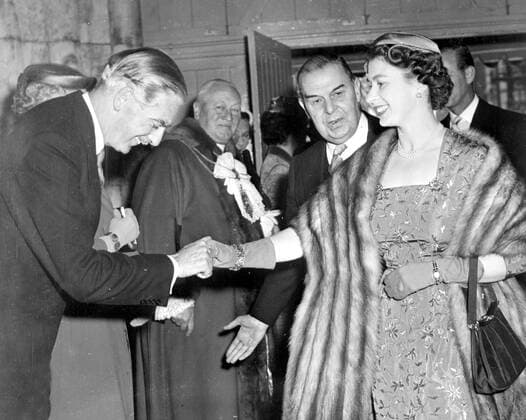 London: British premier, Sir Anthony Eden, who has been under fire from the socialists regarding the Crabb Affair, in the house of commons, greets the queen, who wears a fur wrap and small close fitting hat, on her arrival at the Guildhall, where she attended a ceremony which marked the 40th anniversary of the National Savings Committee, Queen Elizabeth was scheduled to take tea with ex King Leopold of Belgium at Buckingham Palace in the afternoon. 15 May 1956 , Belgien, Adel, Hochadel, König, Königin, Königshaus  UnitedArchives01029276