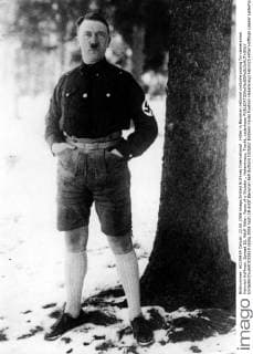 IMAGO History, Zweiter Weltkrieg: 1939 - 1945 Hitler in Bavarian national costume posing for cameraman Heinrich Hoffman. Spread 18, Adolf Hitler: Faces of a Dictator., Hakenkreuz, Tracht, Lederhose  UnitedArchives01033619