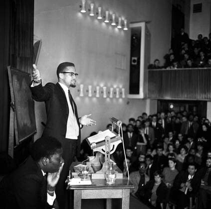 Malcolm X addressing students at the London School of Economics . Malcolm X , leader of the American black muslim sect , was recently refused entry to Paris and was resturned to London by the French authorities on 9th February 11th February 1965  UnitedArchives01192238