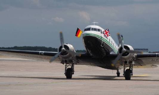 70 Jahre Berliner Luftbrücke am 26. Juni Bln.- ROSINENBOMBER bald wieder am Himmel über Berlin : gestern mittag landete auf dem Flughafen Berlin-Schönefeld eine DC-3; Flugzeuge des gleichen Typs war im Jahr 1948 zur Zeit der Berlin-Blockade durch die sowjetischen Besatzer im Rahmen der Luftbrücke 277.778 mal - alle 90 Sekunden - solch ein Transportflieger gelandet, der neben Versorgungsgütern eben auch Schokolade, Bonbons, Kaugummi und sicher gelegentlich auch Rosinen über Westberlin abwarf; der Förderverein Rosinenbomber wird Teile des für 210.000 $ angekauften Objekts für die Instandsetzung des Juni 2010 verunglückten Flugzeugs aufwänden; Foto : die DC-3 aus Coventry in England ist auf Berliner Boden angekommen ROSINENBOMBER bald wieder am Himmel über Berlin