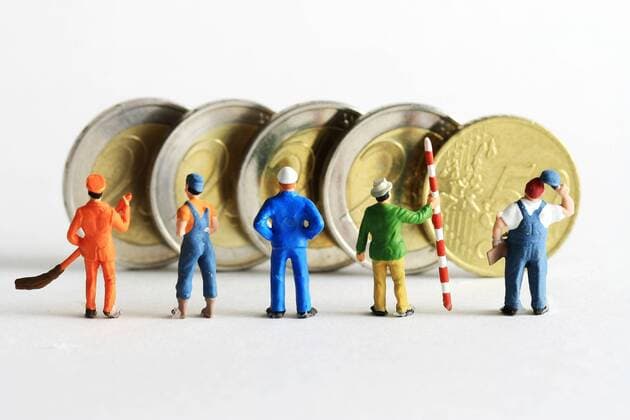 Symbolfoto Mindestlohn:Miniatur Figuren in Arbeitskleidung unterschiedlicher Branchen stehen vor Euro Geldmünzen im Wert von 8,50