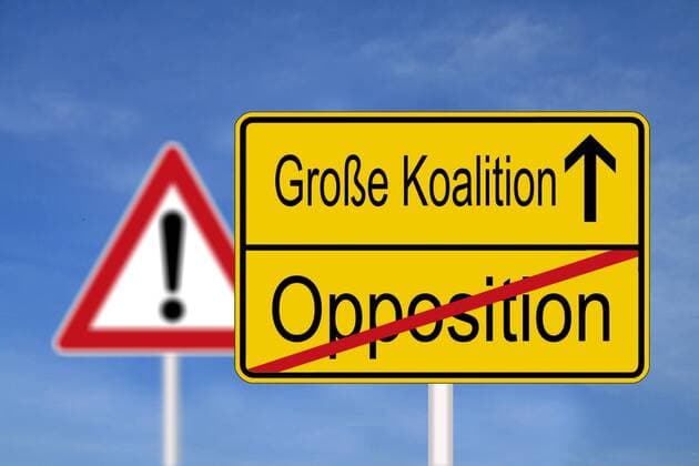 Ortsschild mit Ortsausgang und durchgestrichenem Wort Opposition sowie Ortseingang Grosse Koalition mit Richtungspfeil aufwärts gerichtet vor Verkehrszeichen Achtung Gefahr