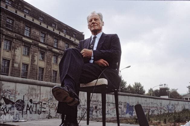 Willy Brandt am 13. August 1986 vor der Berliner Mauer anlässlich des 25. Jahrestags Mauerbaus. Willy Brandt (18.12.1913, Lübeck als Herbert Ernst Karl Frahm - 8.10.1992, Unkel) war ein deutscher sozialdemokratischer Politiker. Während seiner Amtszeit als Regierender Bürgermeister von Berlin, 1957 bis 1966, wurde die Berliner Mauer gebaut. 1966 bis 1969 war er in der Großen Koalition Bundesaußenminister und Stellvertreter des Bundeskanzlers Kurt Georg Kiesinger. 1969 wurde er zum vierten Bundeskanzler der Bundesrepublik Deutschland gewählt, 1974, nach der Enttarnung des DDR-Spions Günter Guillaume, trat er zurück. Für seine Entspannungspolitik, die in die Ostverträge mit Polen und der Sowjetunion mündete, erhielt er 1971 den Friedensnobelpreis. Von 1964 bis 1987 war Brandt Vorsitzender der SPD, von 1976 bis zu seinem Tod, 1992, Präsident der Sozialistischen Internationale. Am 18. Dezembe epd EDITORIAL USE ONLY