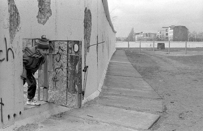 Kind und Mauer Deutschland, Berlin, 26.02.1990, ein Kind schaut durch eine Tür in der Mauer, Mauer am Potsdamer Platz, (Weinhaus Hut),