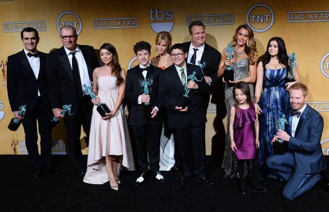 L-R) Actors Ty Burrell, Sarah Hyland, Ed O Neill, Nolan Gould, Julie Bowen, Rico Rodriguez, Aubrey Anderson-Emmons (in front), Eric Stonestreet, Jesse Tyler Ferguson, SofÕa Vergara, and Ariel Winter hold the award they won for Best Ensemble in a Comedy Series - Modern Family, backstage at the 20th annual SAG Awards held at the Shrine Auditorium in Los Angeles on January 18, 2014. the Screen Actors Guild Awards are telecast live on TNT.  LAP20140118600