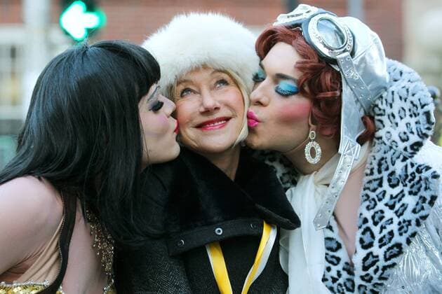 Hasty Pudding Theatricals 2014 Woman of the Year actress Helen Mirren (C) is kissed on the cheek by Harvard seniors Tony Oblen (L) and Ethan Hardy (R) during a parade for the award at Harvard University in Cambridge, Massachusetts on January 30, 2014.  BOS2014013002