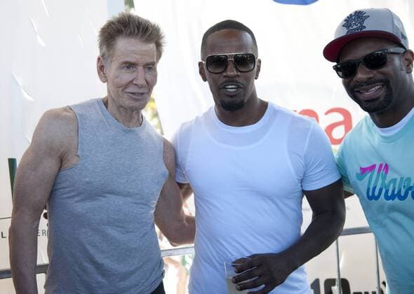 Fashion designer Calvin Klein (Left) poses for a photo with actor Jamie Foxx (Center) and DJ Irie, the voice of the Miami Heat basketball team at the WILDFOX Model Beach Volleyball Tournament in Miami Beach, Florida, February 9, 2014. Model Agencies will Battle in a live Beach Volleyball Tournament for South Beach bragging rights .  MIA20140209107