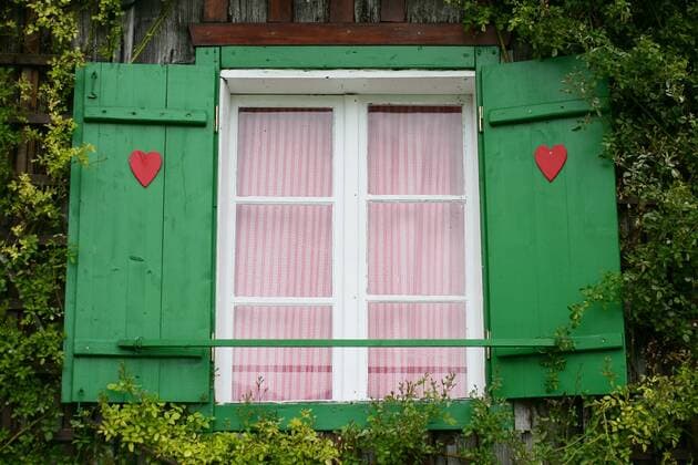 Grüne Fensterläden mit roten Herzchen sind in Steinbach am Attersee zu sehen. Fensterläden mit Herzen