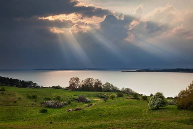 Sonnenstrahlen vor Wolkenwand über dem Mönchgut
