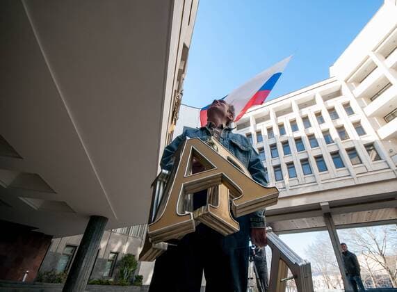 Sign removed from Supreme Council in Simferopol Workers remove the sign The Supreme Council of the Autonomous Republic of Crimea in Ukrainian, Russian, and Crimean Tatar languages on March 18, 2014 in Simferopol, Russia EN_01121327_0029 