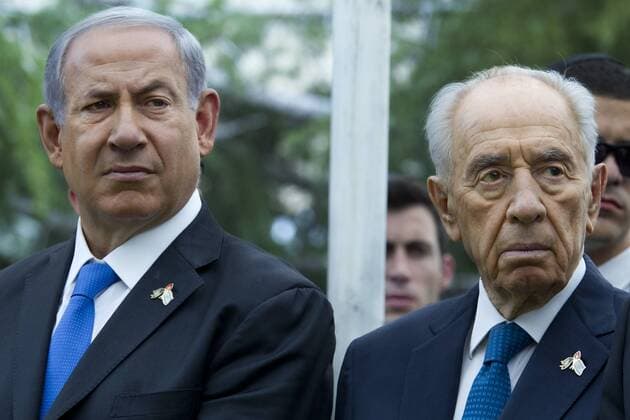 Israeli Prime Minister Benjamin Netanyahu (L) next to President Shimon Peres as an honor guard shoots volleys during the ceremony marking Remembrance Day for Fallen Soldiers and Victims of Terror held on Mt Herzl Military Cemetery in Jerusalem on May 5, 2014.  JERX2014050514