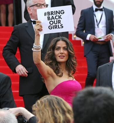 Salma Hayek arrives on the steps of the Palais des Festivals before the screening of the film Saint Laurent during the 67th annual Cannes International Film Festival in Cannes, France on May 17, 2014. Hayek held up a sign in support of the schoolgirls being held captive by Nigerian Islamic extremist group Boko Haram.  CAN20140517714