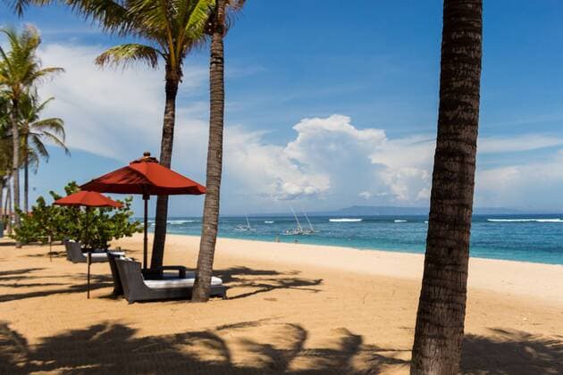 Tropischer Strand mit Sonnenliege und Sonnenschirmen mit weißem Sand in der Karibik Beach umbrellas on a beautiful beach in Bali pwas30